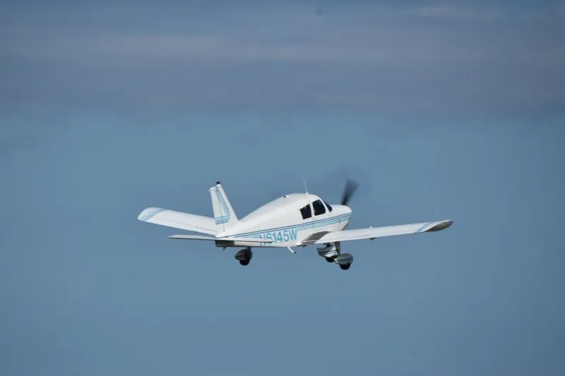 Piper Cherokee 140 flying along the Gulf coast